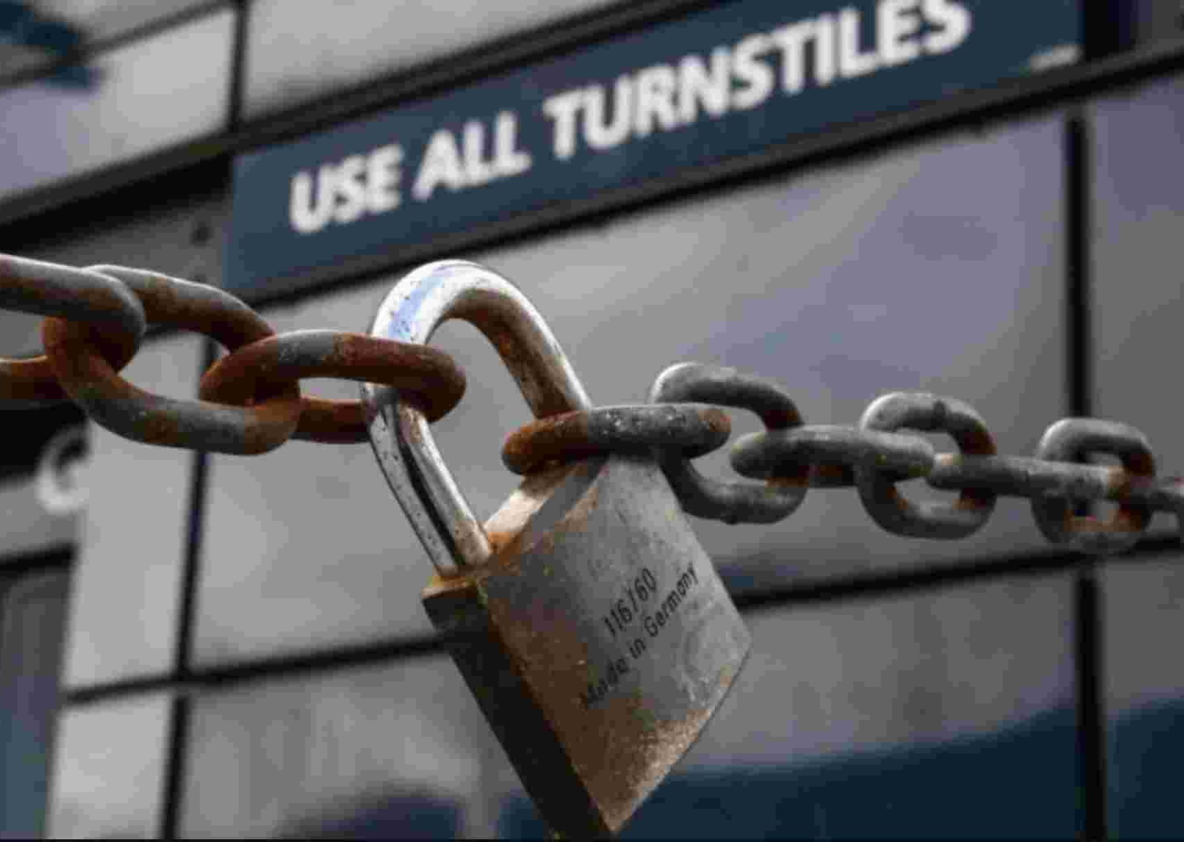 A locked padlock in front of a sports turnstile