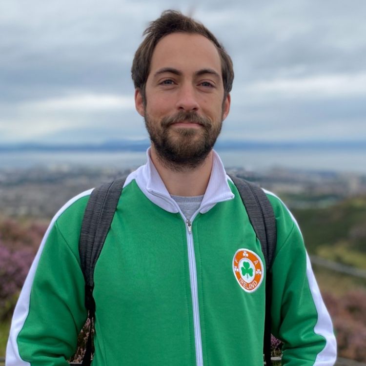 Joey Millar smiling outdoors in a dark jacket
